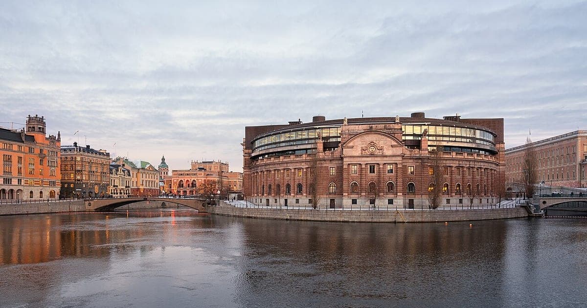 Riksdagshuset på Helgeandsholmen i Stockholm en vinterkväll, med vatten i förgrunden